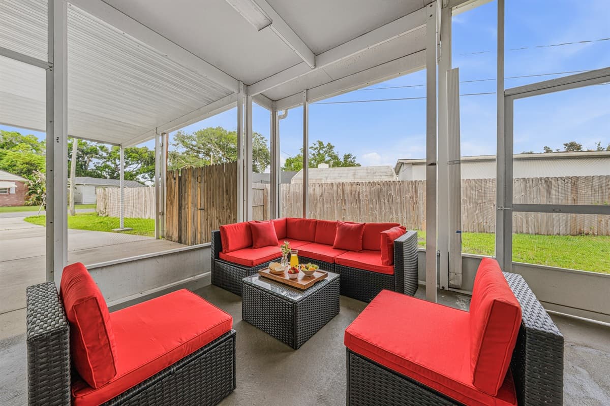 Screened-in patio with cozy seating and views of the private fenced backyard.