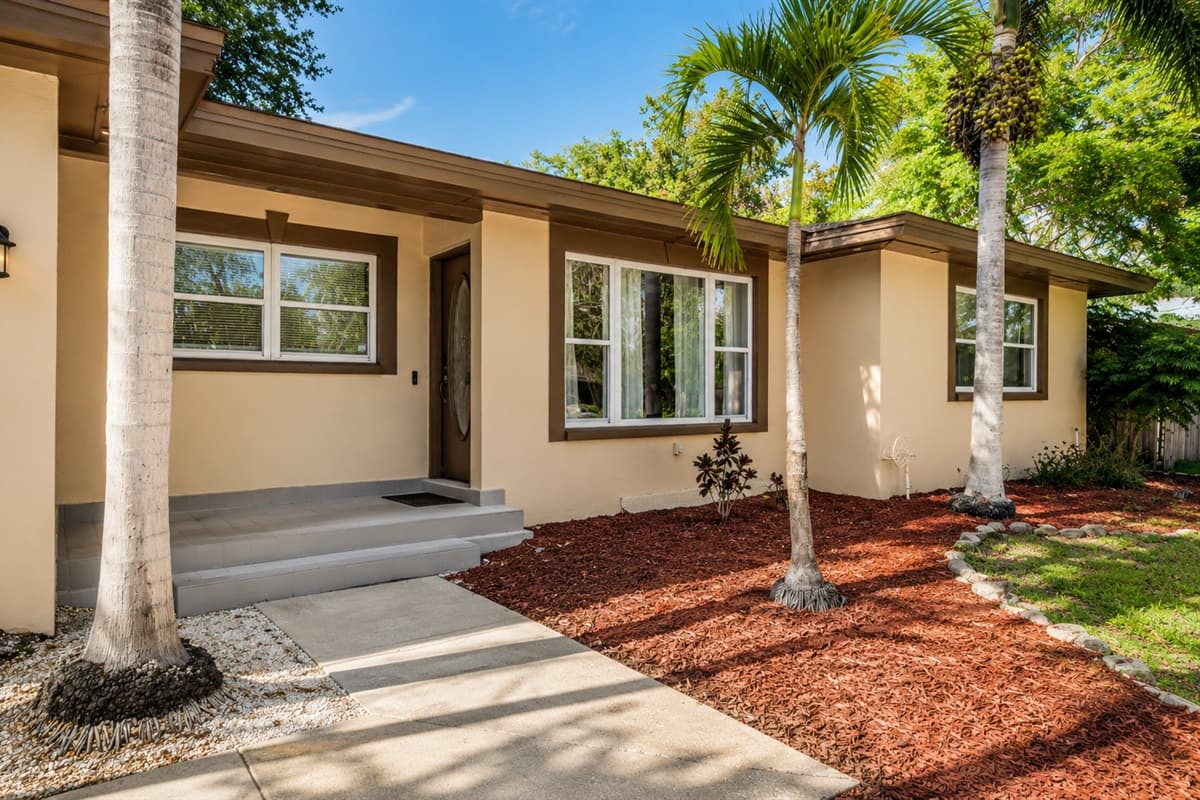 Beautiful exterior view showcasing the home’s modern design and lush palm trees.
