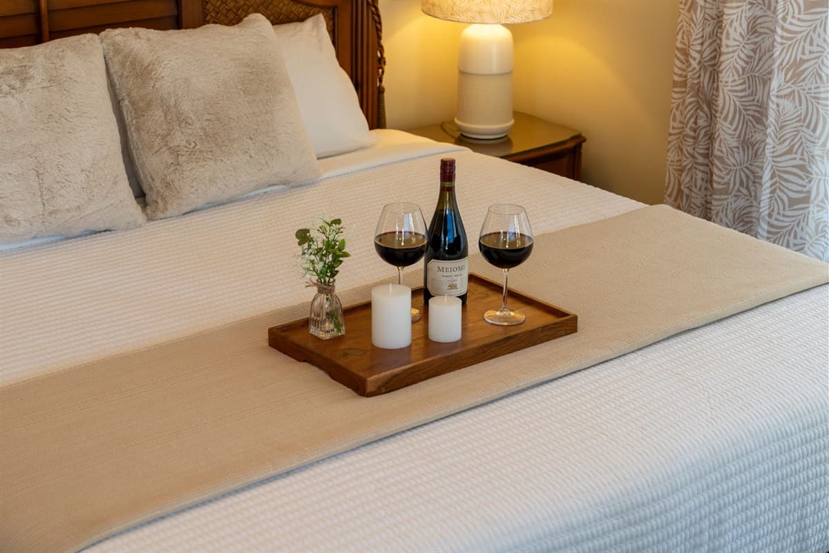 Enjoy restful nights in this tranquil master bedroom complete with a ceiling fan, cozy lighting, and a comfortable king-sized bed.
