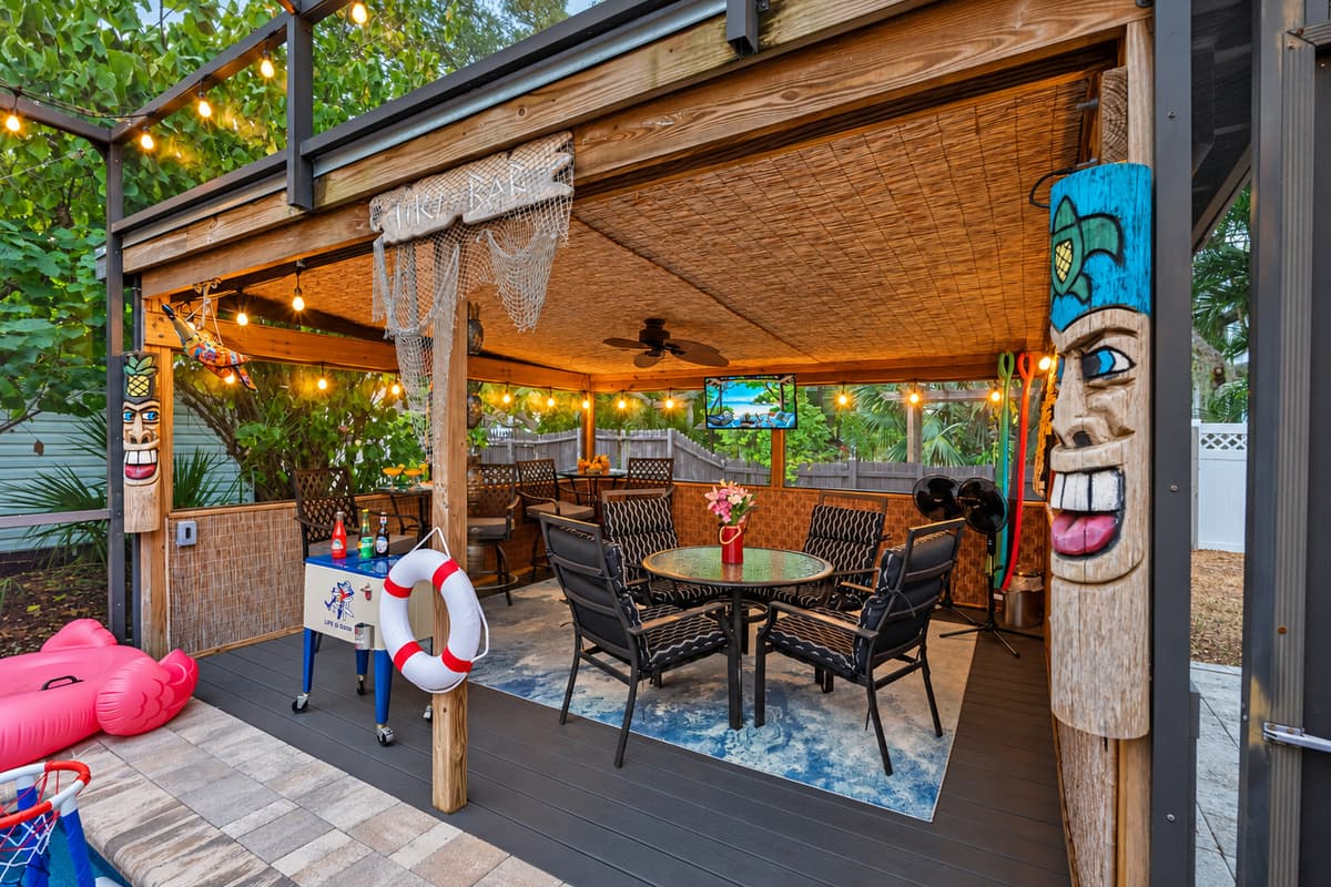 Relax and play in this spacious, covered patio that overlooks the pool area! With plenty of comfortable seating, fun tiki decorations, a TV for entertainment, and a shaded spot for snacks and drinks.