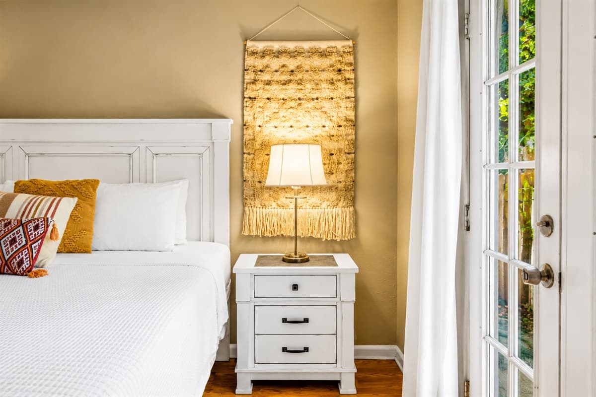 Cozy bedside view showcasing warm lighting, elegant décor, and peaceful outdoor access.