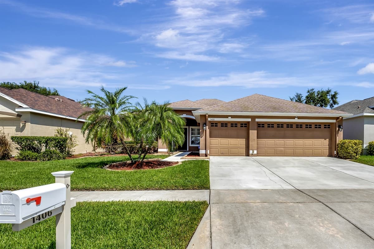 The stunning exterior of the house displays a lush green front lawn and an exceptionally roomy driveway.