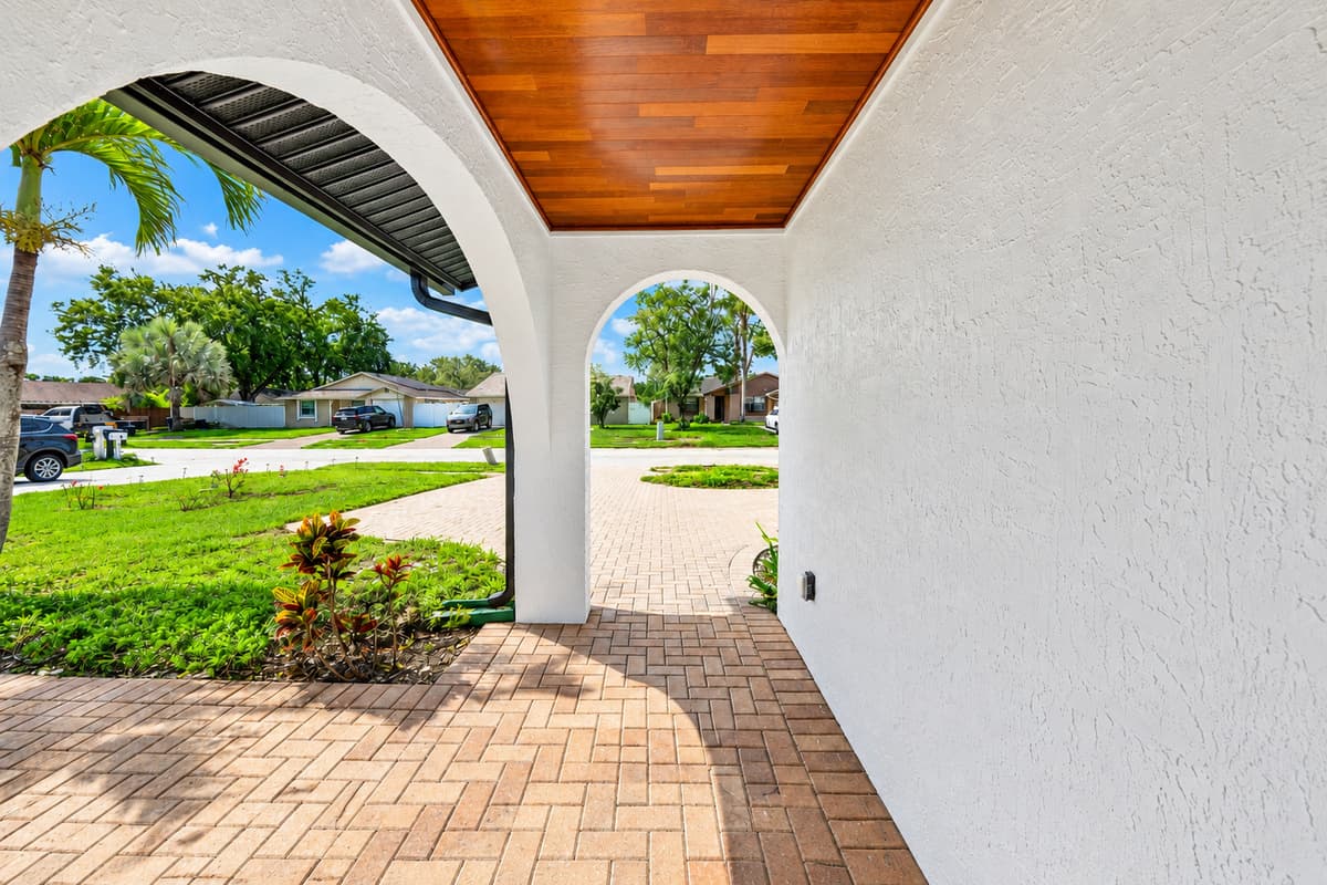 Covered front porch offering shade and a welcoming space to arrive and depart comfortably throughout your stay.