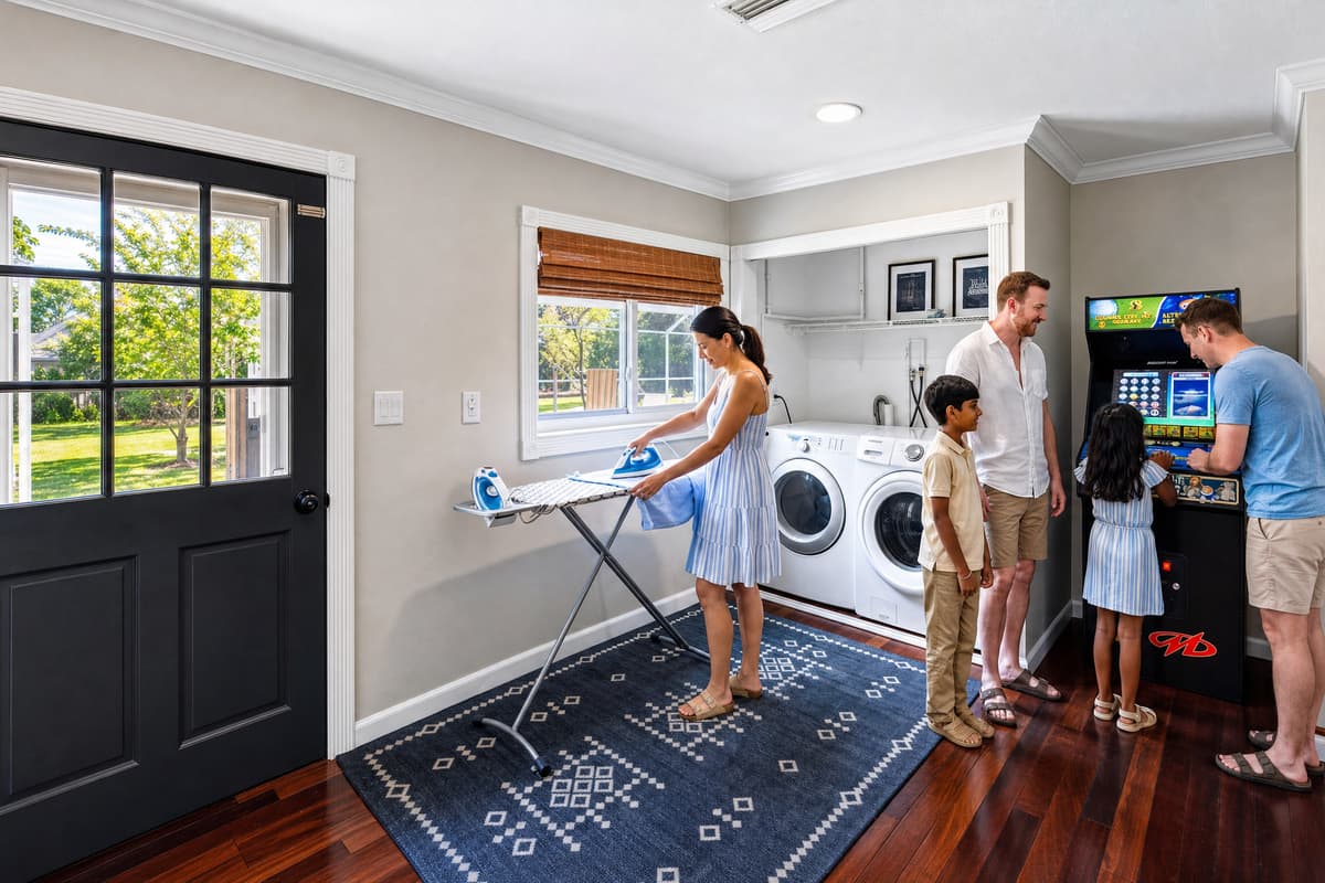 Bright laundry space with modern appliances and a nearby arcade game for added fun, close to game room.