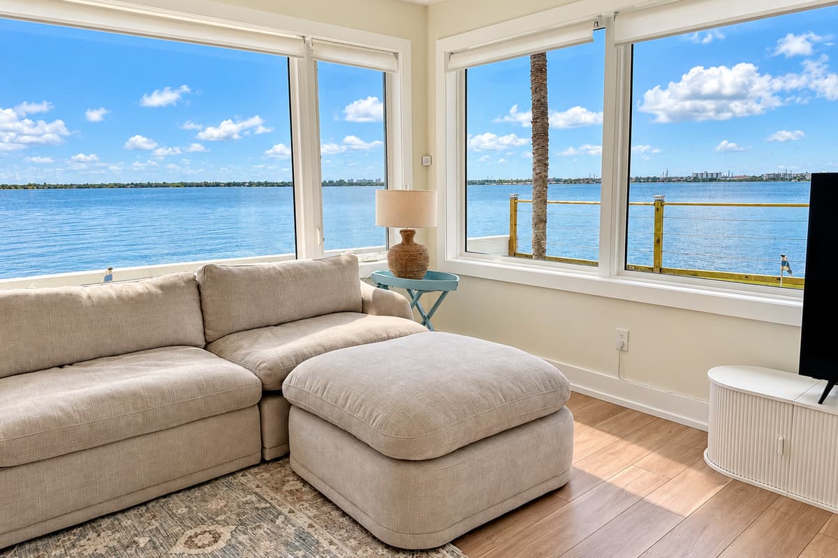 Waterfront living room with comfortable seating and wide water views.