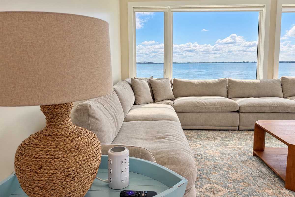 Waterfront living room with comfortable seating and wide water views.