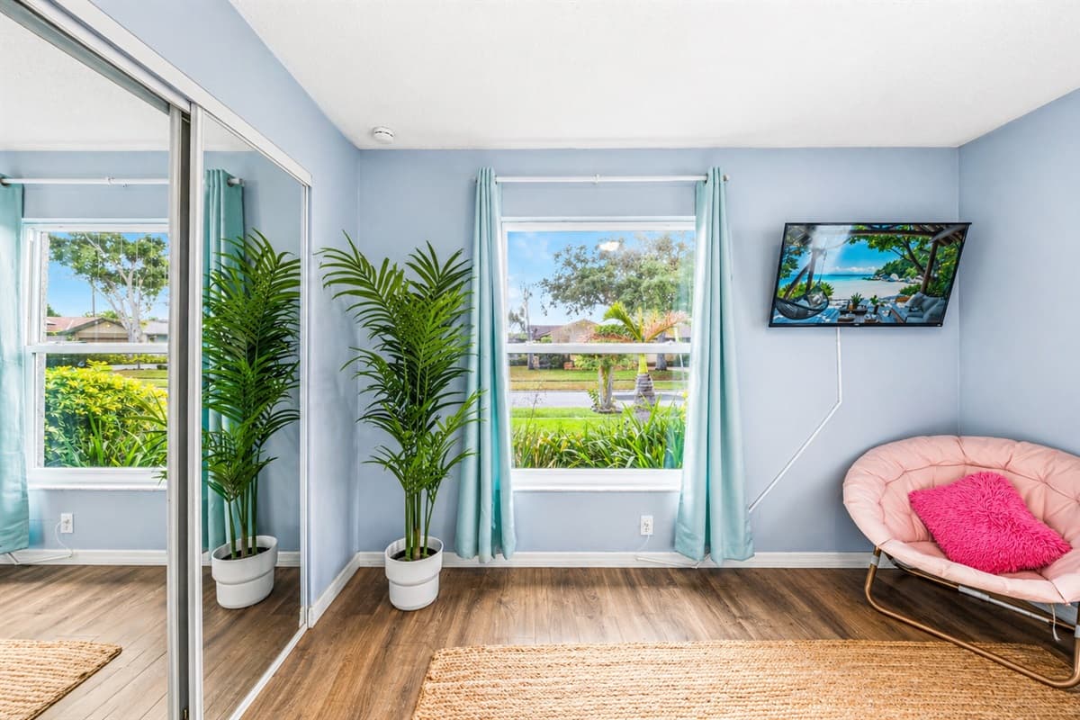 Bright space with large windows, natural light, and a cozy lounge chair for relaxing.