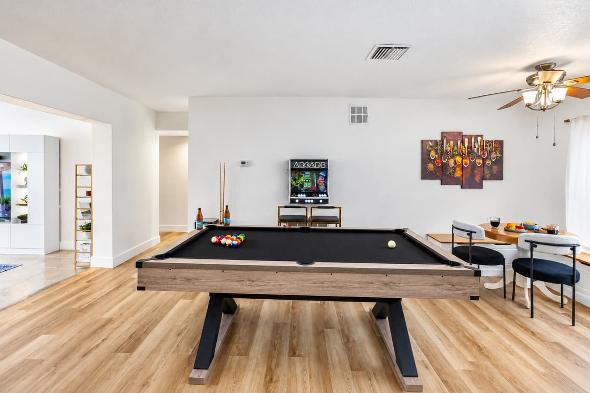 A perfect space for playful competition, this entertainment room features a sleek black pool table, foosball, and nostalgic arcade games.
