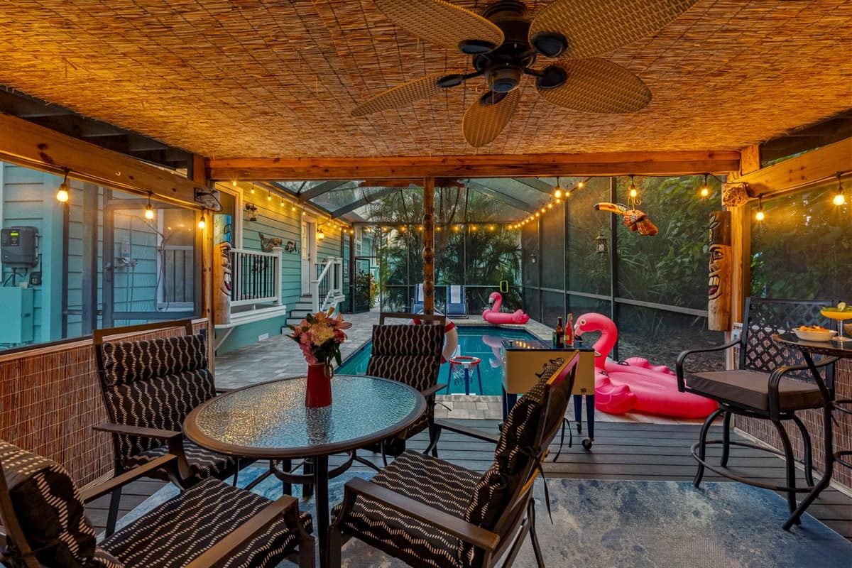 This tropical-themed patio is a guest favorite! Featuring a covered lounge area with plenty of seating, outdoor TV, fun tiki décor, and a bar setup.