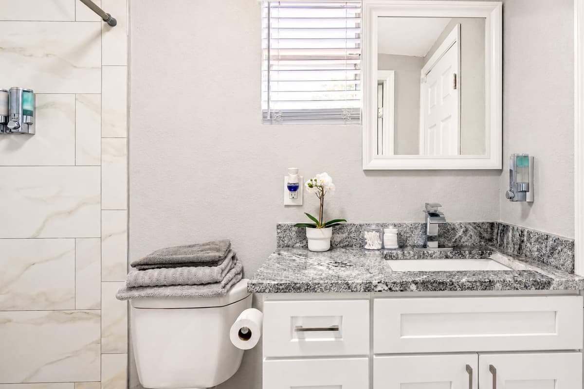 The white tiles in the shower, and light grey painted walls create a crisp and clean backdrop that sets the tone for the entire space.