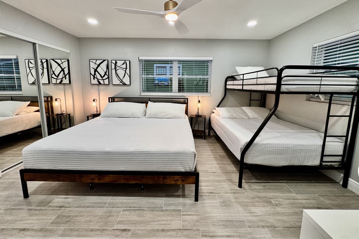 This room features a king size bed, a bunk bed that includes a twin bed on the top and a full-size bed on the bottom, making it ideal for children or adults who enjoy a more playful yet functional setup.