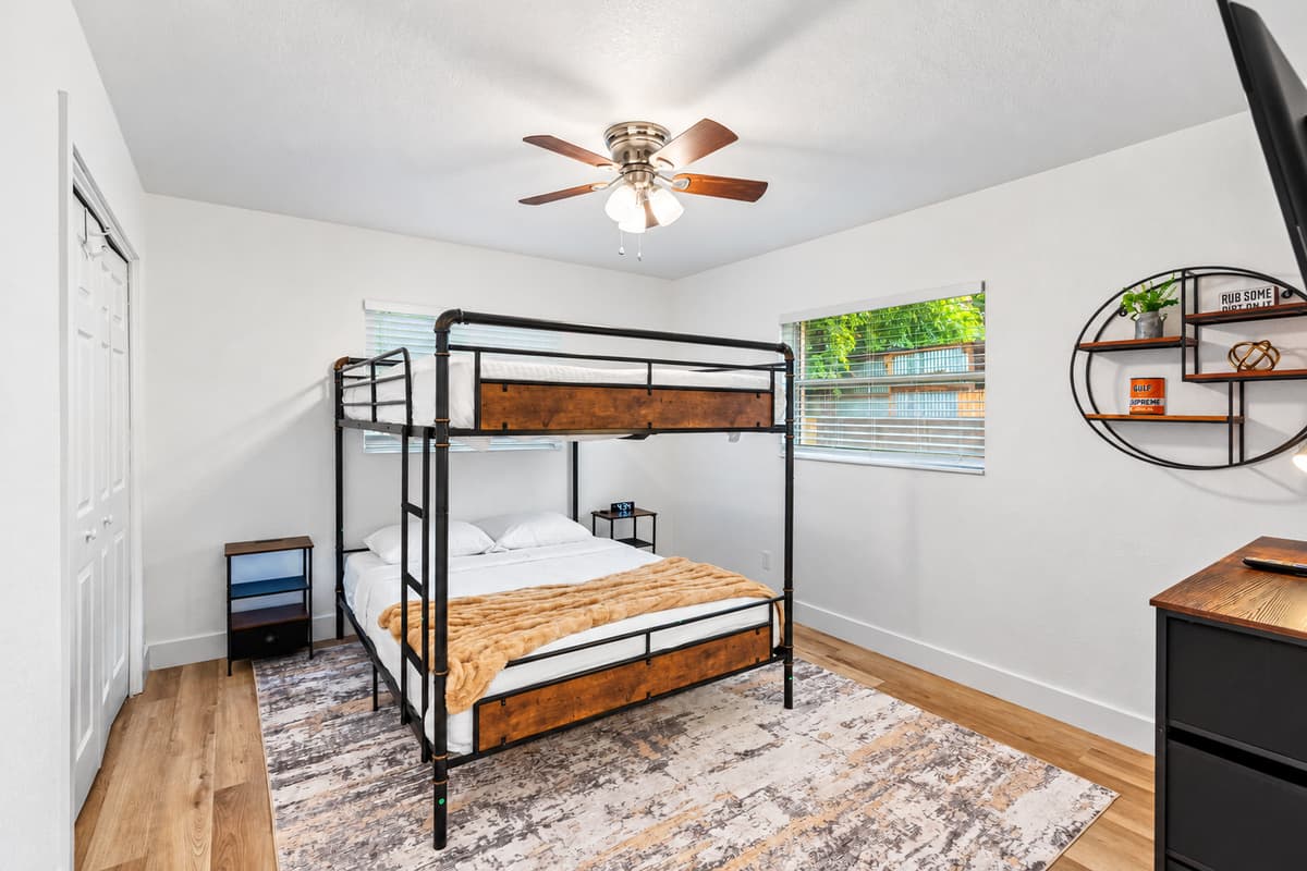 This modern bunk room offers space-saving design with a touch of industrial flair—equipped with soft bedding, ample lighting, and relaxing vibes.