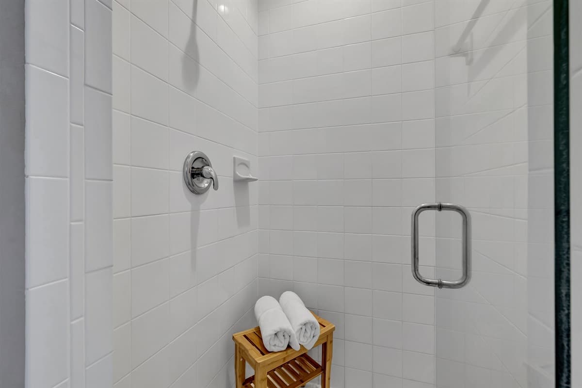 Adjacent to the bathtub, a walk-in shower stands ready to envelop you in a cascade of warm water, washing away the stresses of the day.