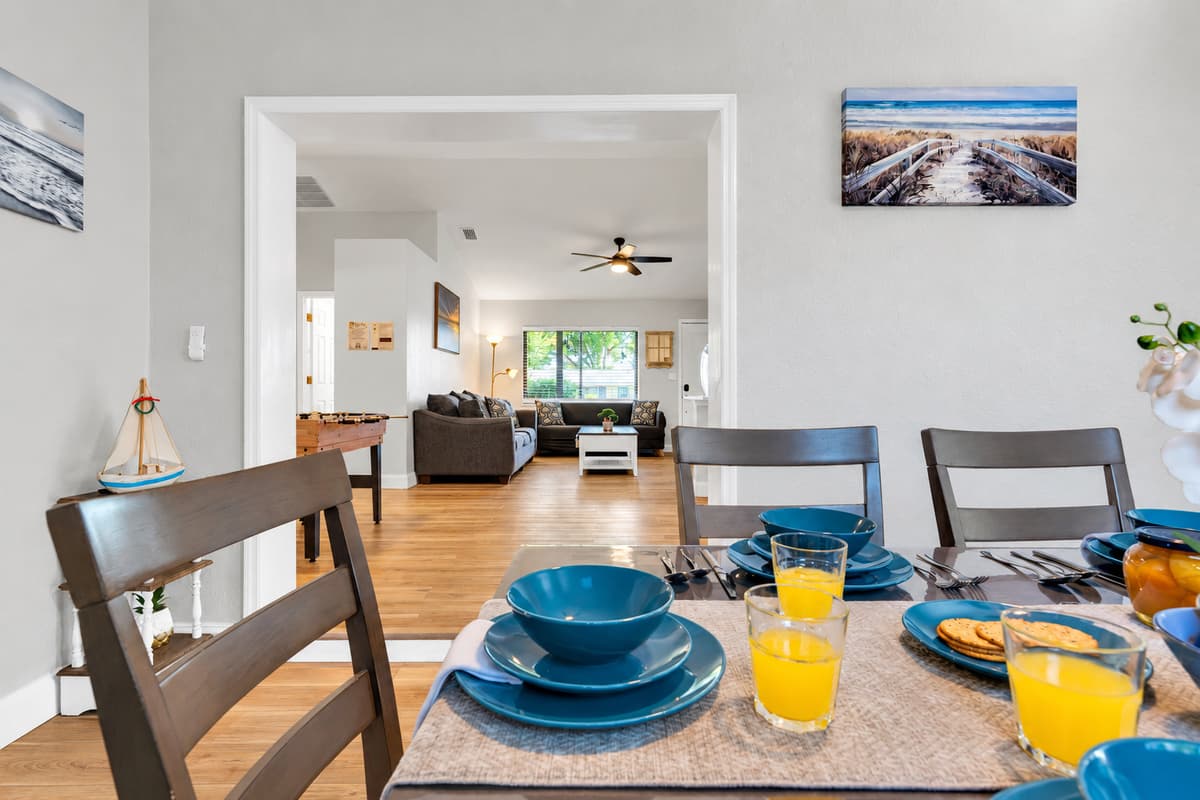 The dining table sits in the open living area, so whoever is cooking never gets left out of the conversation. Kitchen, table and living room all read as one space — which is exactly how big groups actually live.