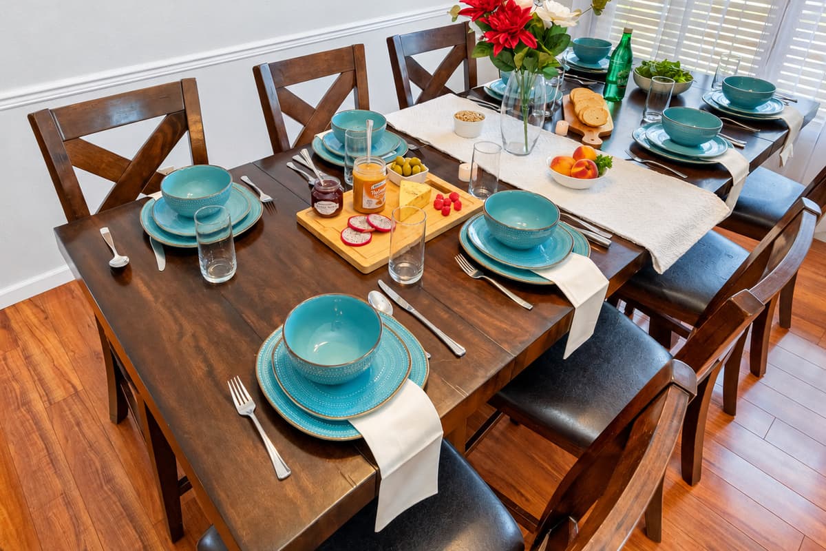 This stylish dining area features seating for eight, natural light, and charming tableware—ideal for memorable mealtime moments.