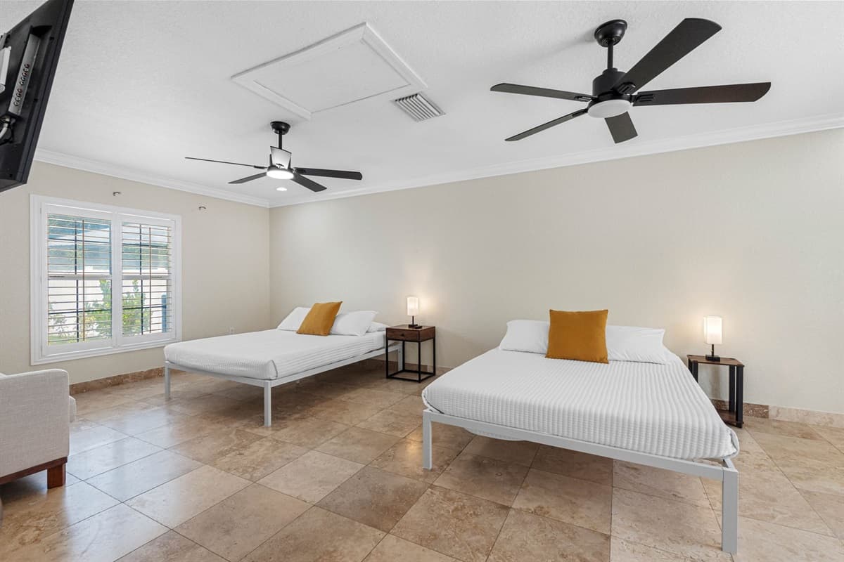 This inviting space features two plush queen-sized beds, each outfitted with soft, hotel-quality linens, cozy comforters, and an abundance of pillows to ensure a restful night’s sleep for every guest.