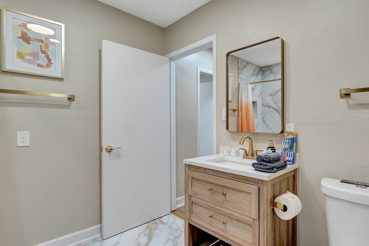 Elevate your stay to a golden standard of luxury in this lavish bathroom retreat.