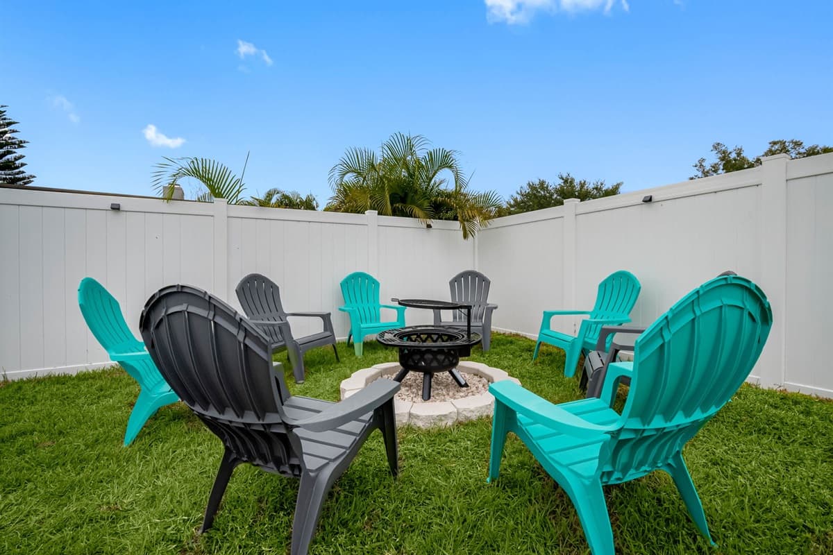 This fully fenced backyard offers everything you need for fun and relaxation — a sparkling pool, outdoor dining area, and a fire pit surrounded by Adirondack chairs for cozy gatherings.