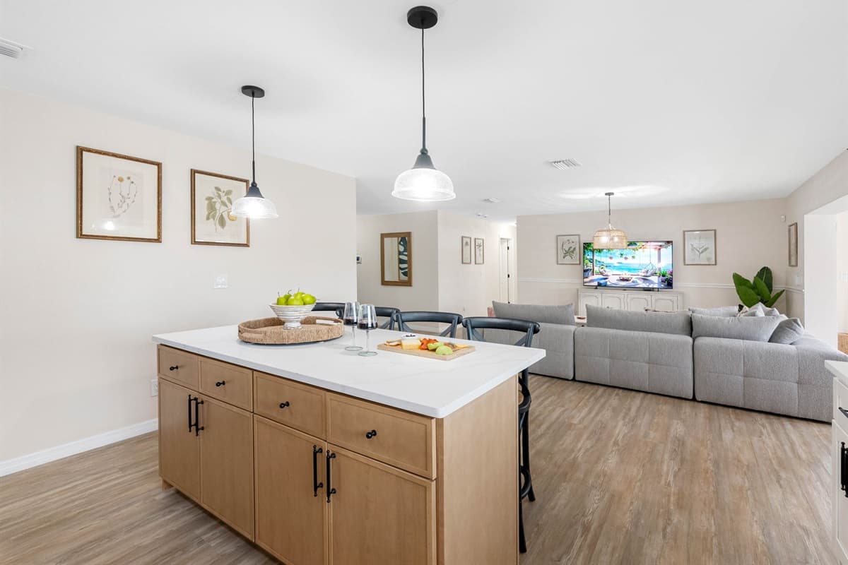This dining space features a sleek wooden table, coastal wall décor, and a statement pendant light — blending function and style effortlessly.