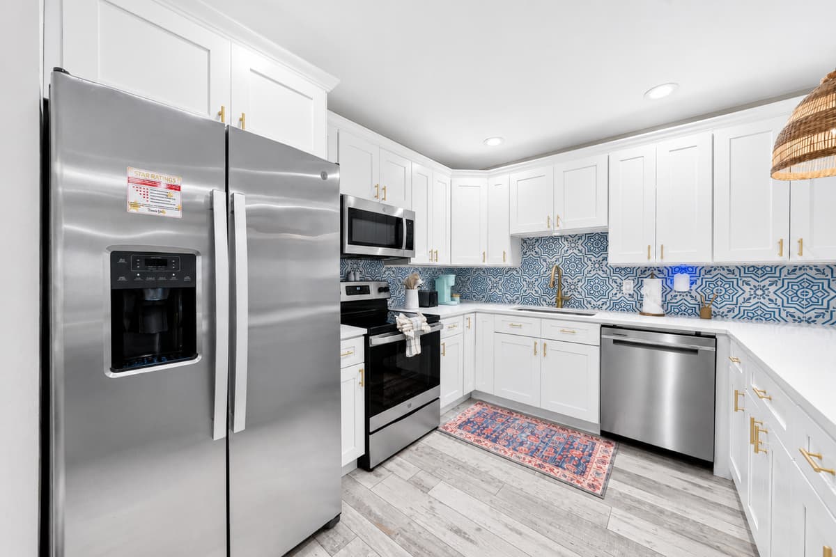 Long view of the kitchen showcasing generous counter space, breakfast bar seating, and direct access to the dining area.