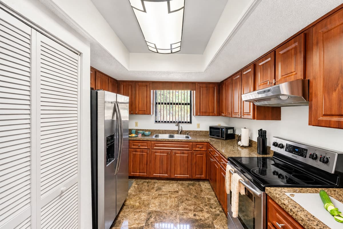Paired with the rich cabinetry and glossy marble-look tile floors, the space feels both luxurious and functional.