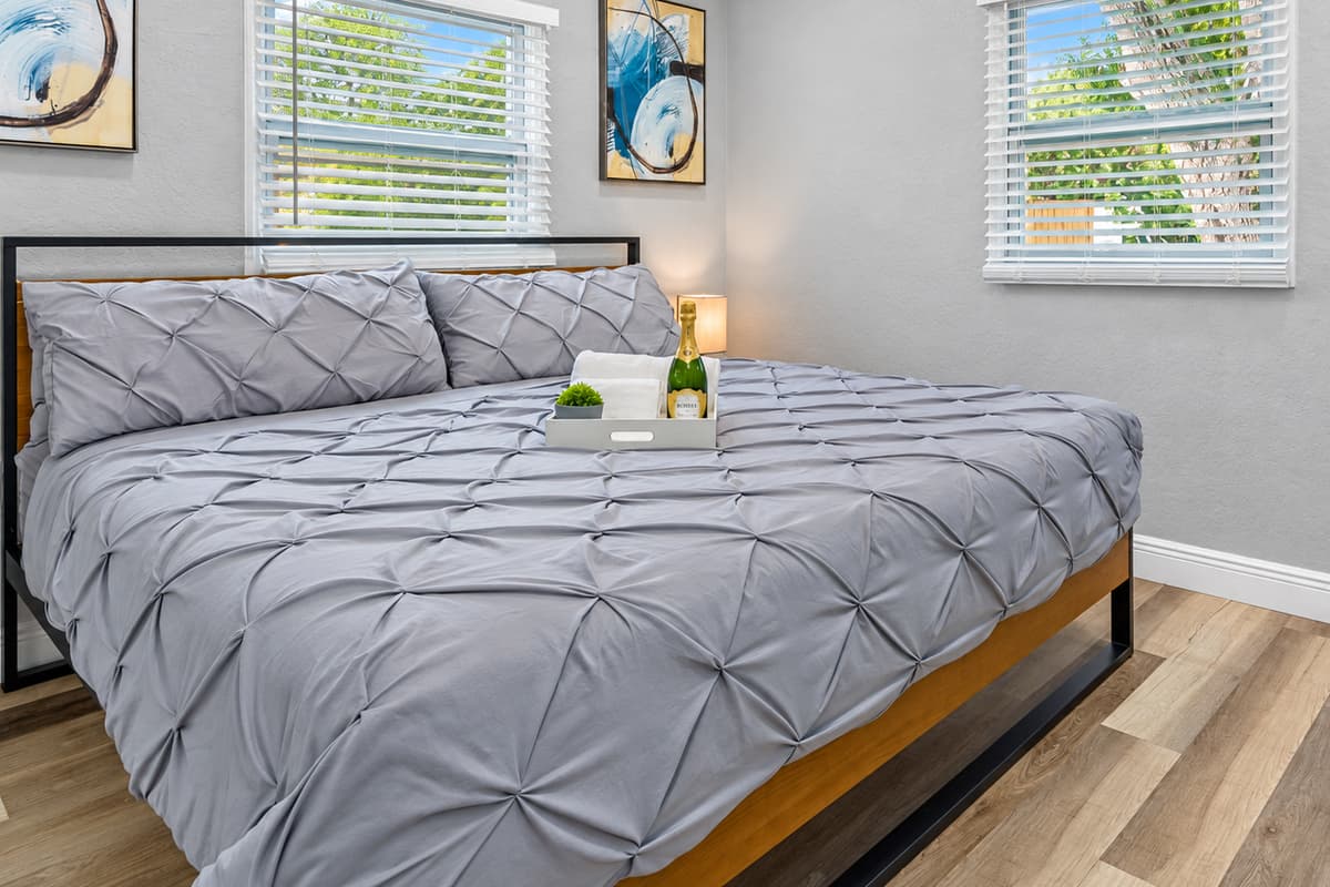 Space to unwind in the king suite. A wide king bed, bedside tables, drawers, and bright windows. Room to unpack and relax away from the busy common areas.
