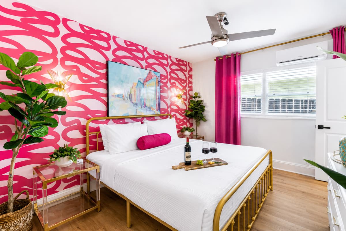 Unwind in the spacious bedroom featuring a plush king-size bed, bold tropical décor, Smart TV, and a calming atmosphere for restful nights.