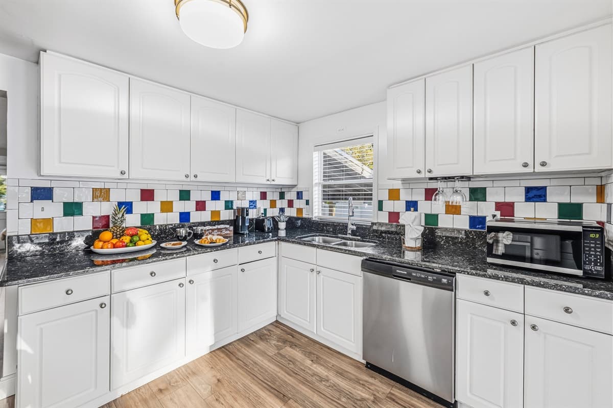 Bright, fully equipped kitchen with modern appliances and colorful backsplash.