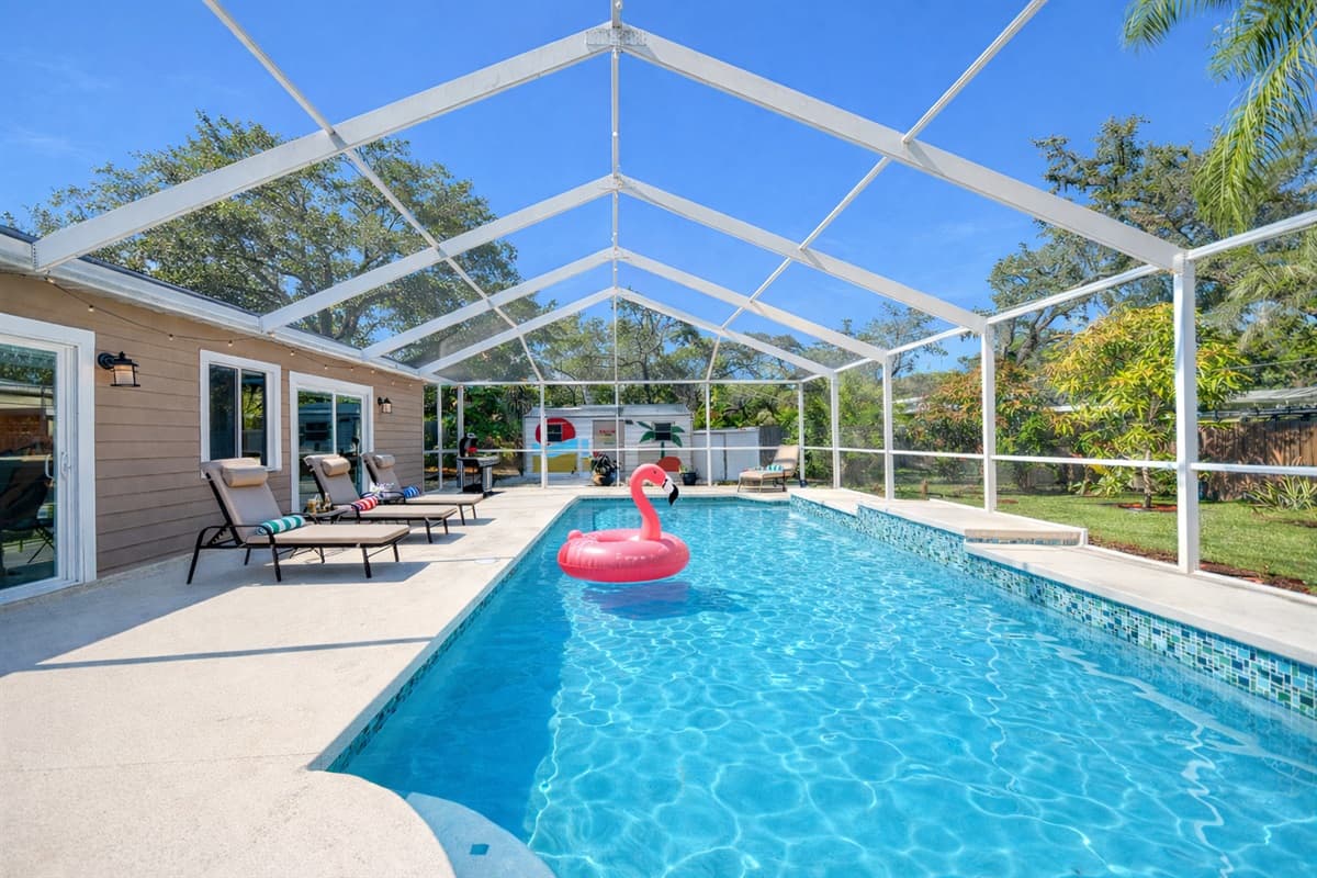 A stunning full-length view of the private screened pool with serene wooded surroundings, offering both privacy and a peaceful retreat.