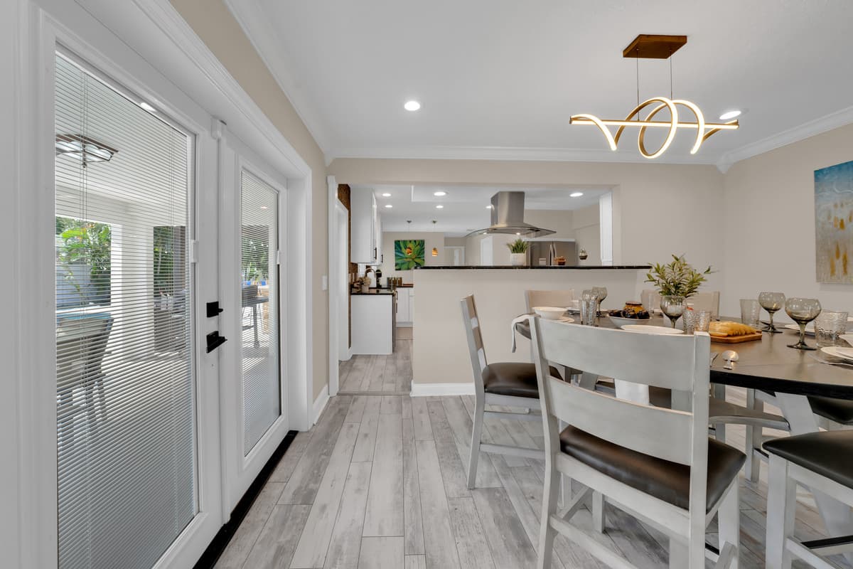 The dining table sits just steps from French doors to the patio, blurring the line between indoor meals and outdoor living