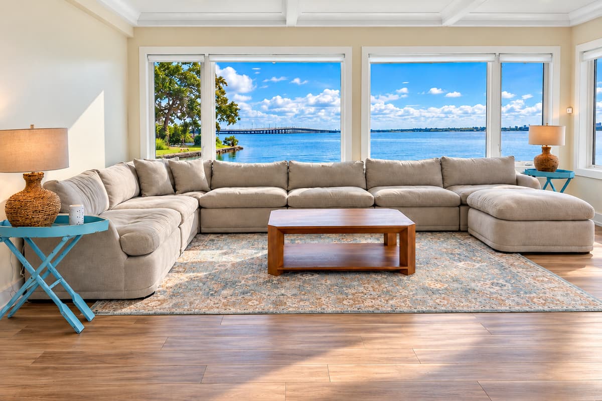 Waterfront living room with comfortable seating and wide water views.