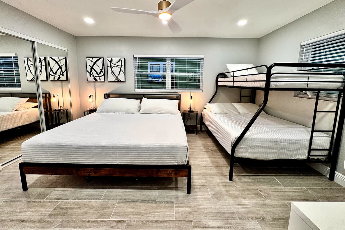 This room features a king size bed, a bunk bed that includes a twin bed on the top and a full-size bed on the bottom, making it ideal for children or adults who enjoy a more playful yet functional setup.