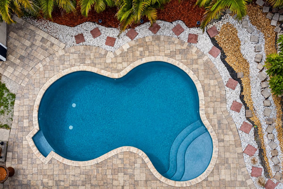 Aerial view of the sparkling private pool surrounded by mature landscaping and a fully fenced yard.