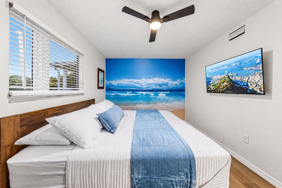 King bedroom with bright windows and ocean-inspired décor for a refreshing, beachy atmosphere 