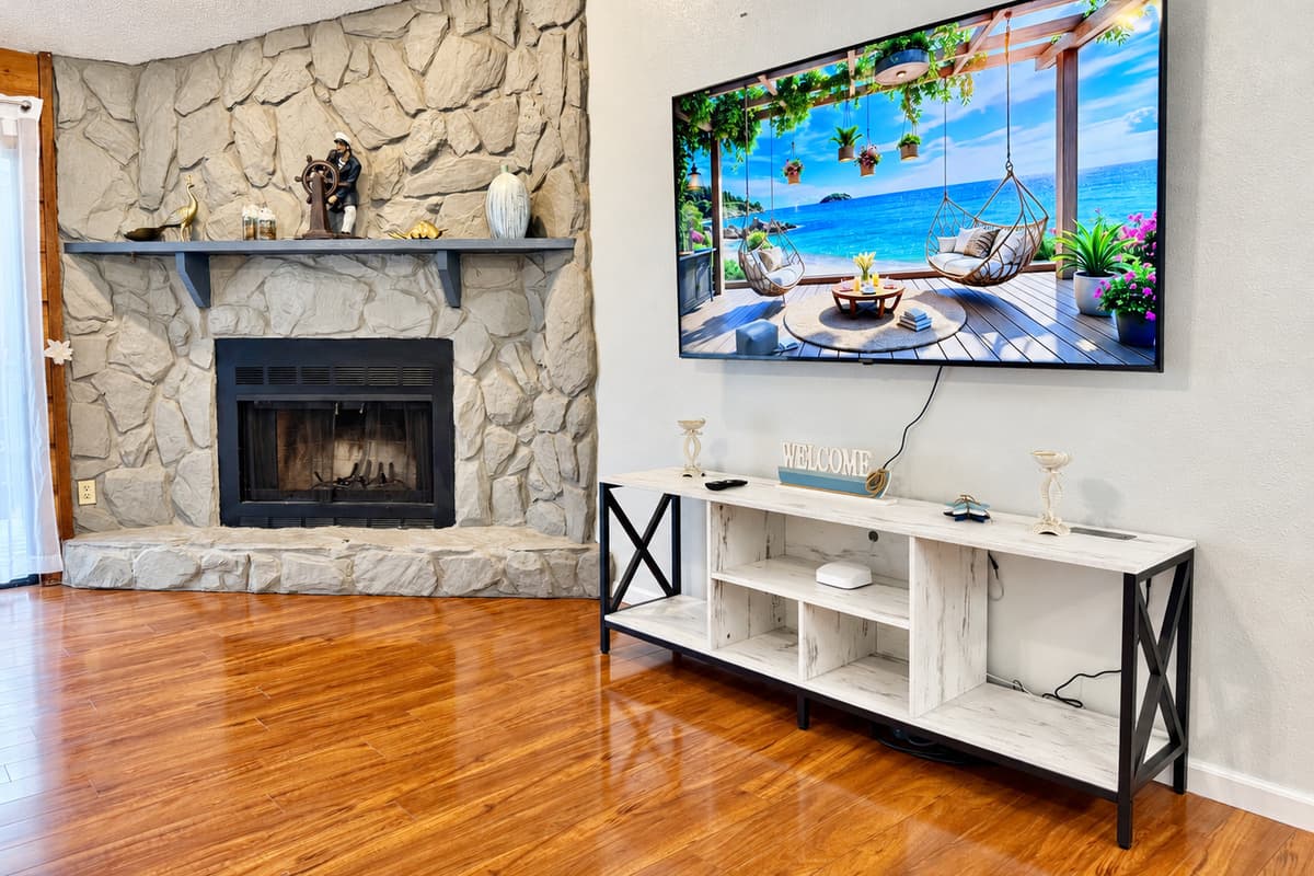 Anchoring the room is a stunning floor-to-ceiling stone fireplace, creating a rustic focal point that exudes coziness and character.