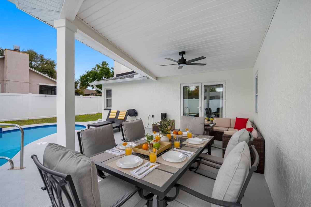This inviting patio space offers the best of outdoor living with cozy seating, modern dining furniture, and a poolside view — perfect for enjoying meals and moments under the Florida sky.