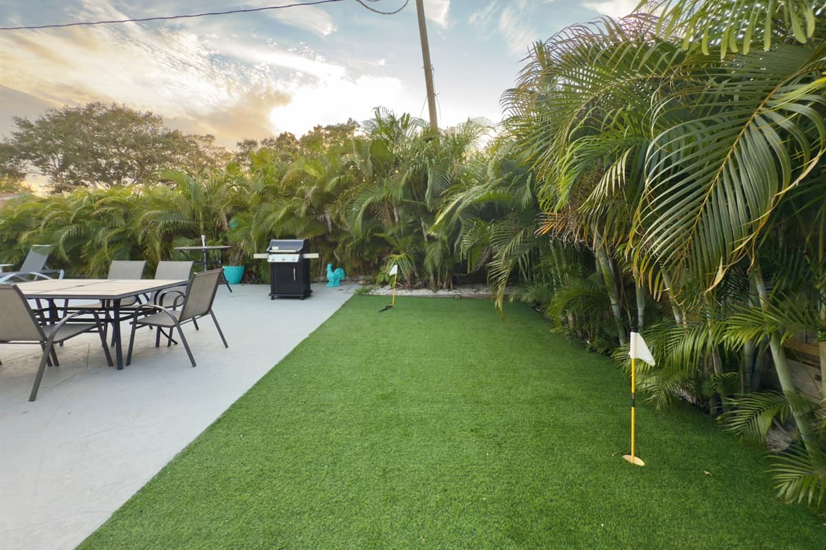 Surrounded by tall palms and greenery, the backyard feels private and peaceful.