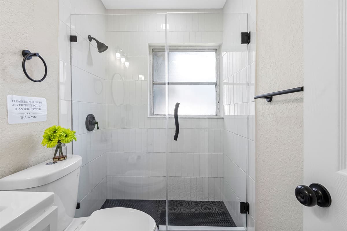 A frosted privacy window allows natural light to stream in while keeping the space discreet and serene.