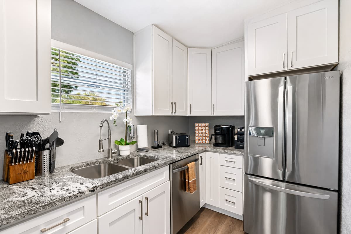 The sleek grey and black appliances add a modern touch and create a beautiful contrast against the white backdrop.