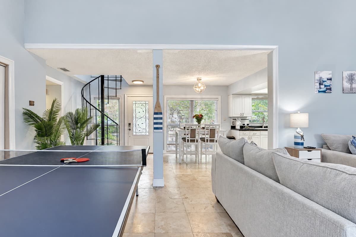 The ping pong table, strategically placed for easy access, adds a dynamic touch to your living space.