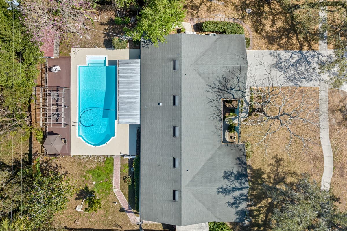 The pool area is surrounded by lush greenery and mature trees, providing a sense of privacy and seclusion that is rare in today's fast-paced world.