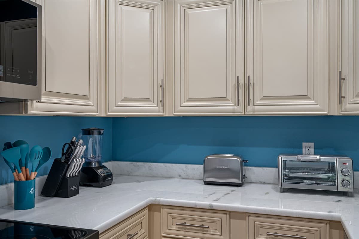 Adding a burst of personality to the space are the vibrant blue painted walls. The hue evokes a sense of tranquility and serenity, providing a visually refreshing backdrop as you prepare delectable meals.