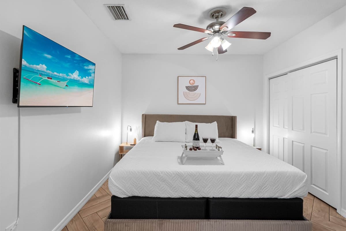 With crisp white bedding, natural wood tones, and ambient lighting, this stylish room offers a king bed, flat-screen TV, and direct bathroom access.