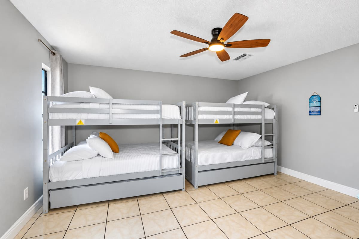 Featuring two sets of sleek modern gray bunk beds with full over full and twin trundles configurations.