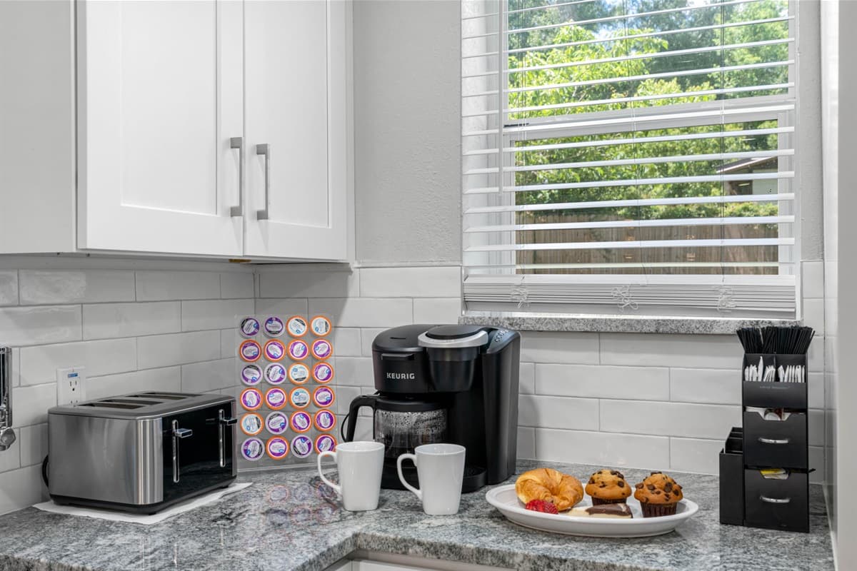 Accents such as a stylish backsplash, sleek hardware, and thoughtfully chosen decor items add the finishing touches to this exquisite kitchen.