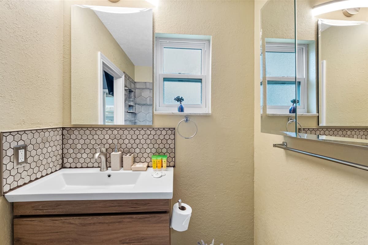 Updated bathroom with a modern vanity and elegant hex-tile shower.
