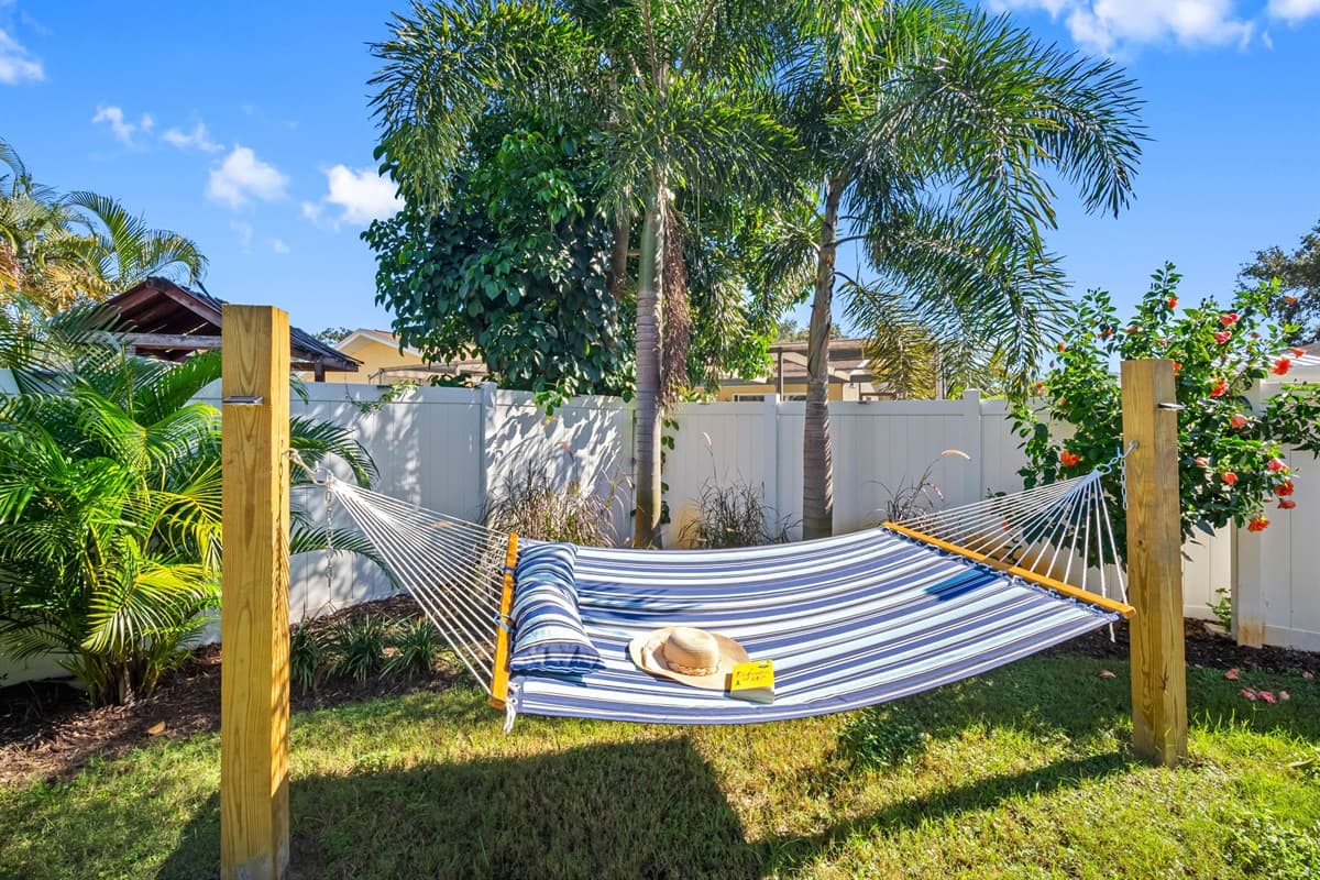Lounge under the palm trees in the cozy hammock or gather around the turquoise firepit for evening drinks. The backyard is fully fenced for privacy and beautifully lit at dusk, offering the perfect mix of relaxation and fun.