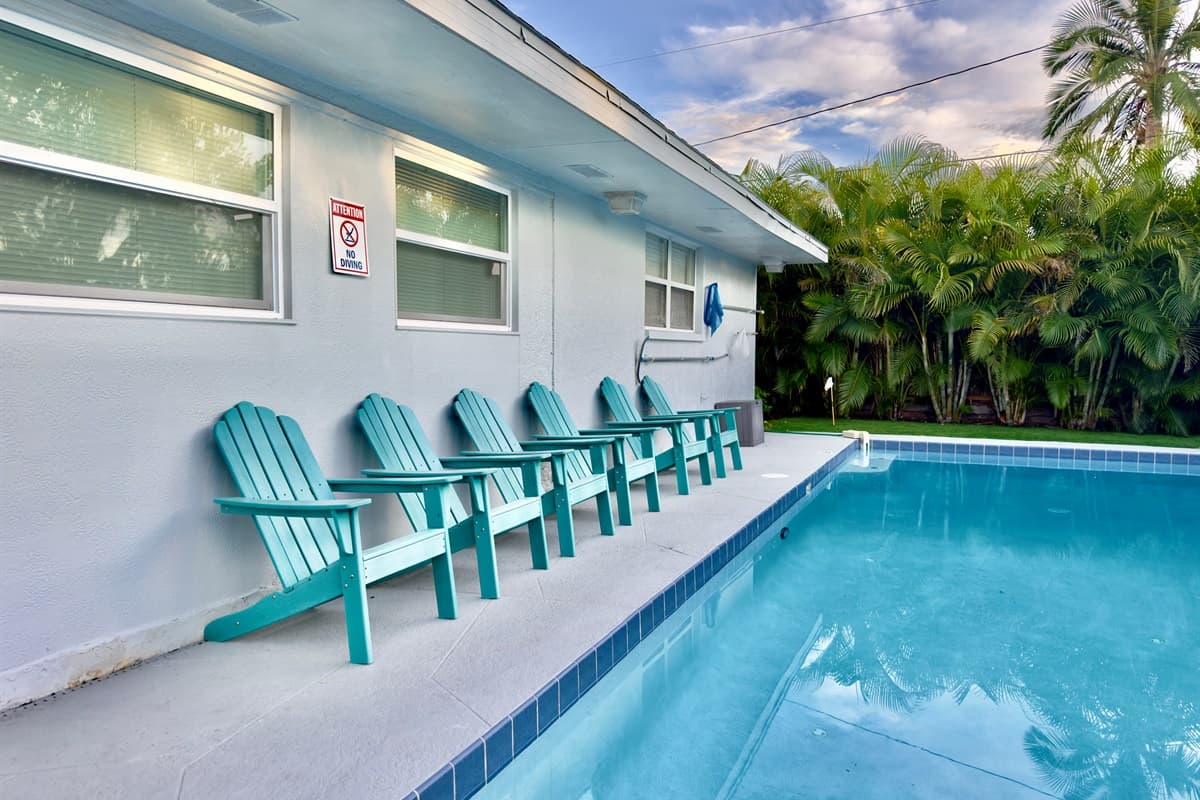 The crystal-clear pool is the centerpiece of this backyard retreat, surrounded by palms for a resort feel.