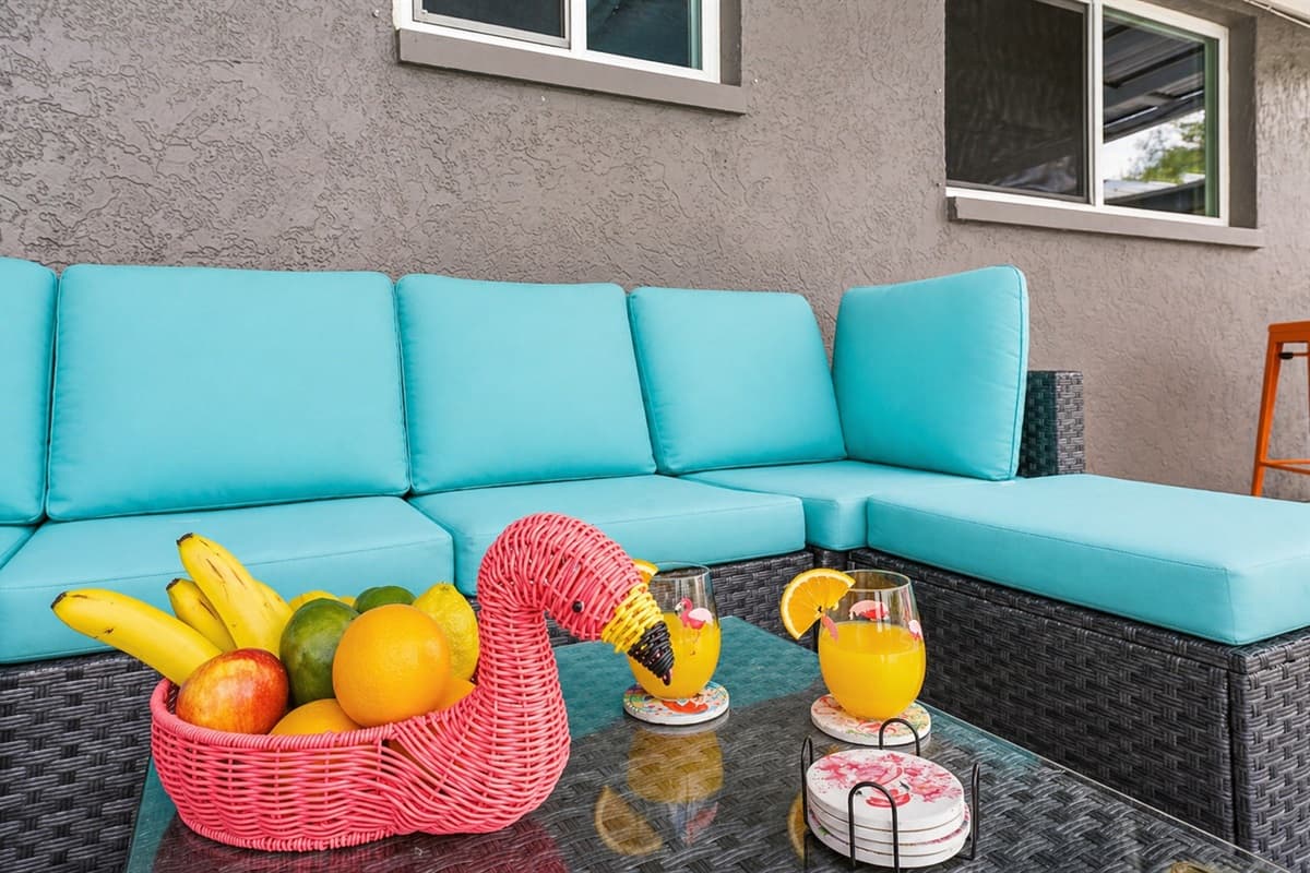 Close-up of cozy outdoor seating with tropical touches and poolside ambiance. (Food setup for staging purposes only)