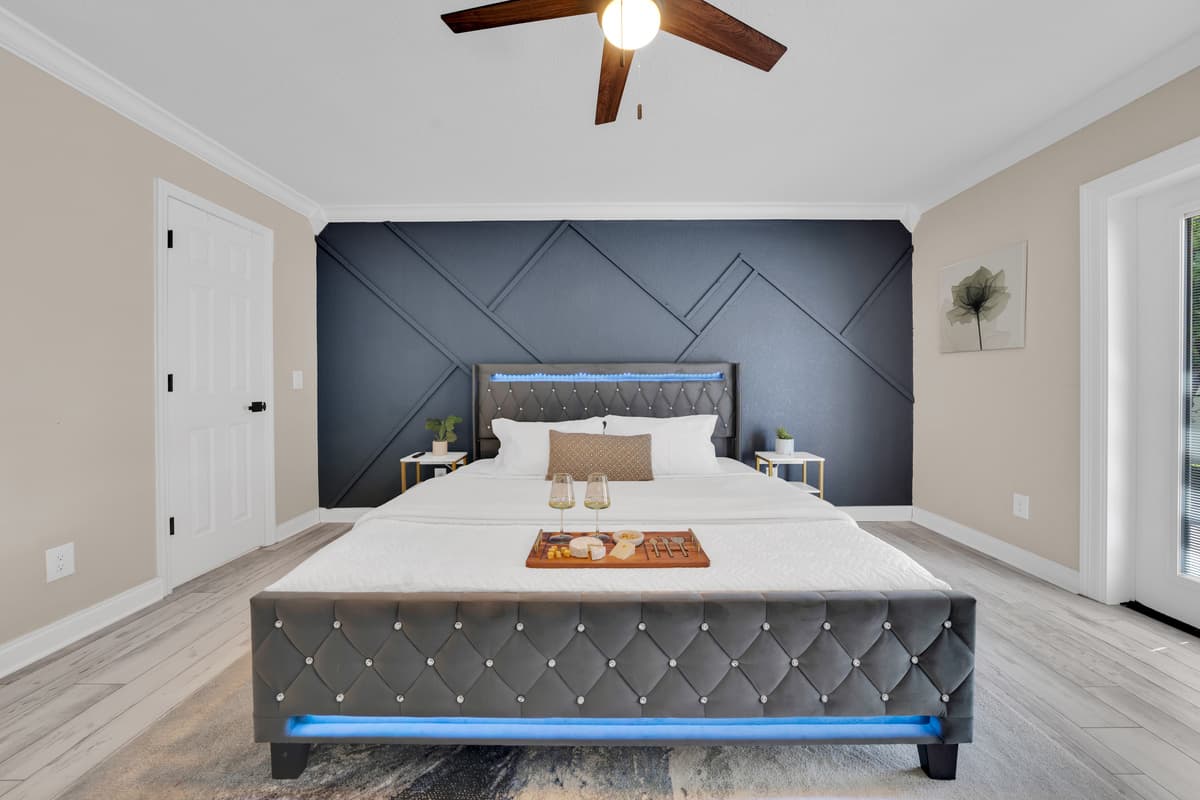 Soft natural light and a dramatic geometric accent wall give the primary suite a boutique-hotel feel